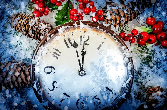 new-year 1 Winter holiday scene with a frosted clock showing midnight among snow, pine cones, and red holly berries.