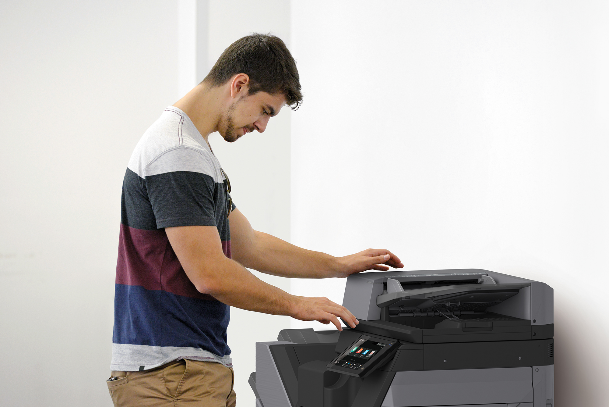 One young adult male using a high tech photocopier