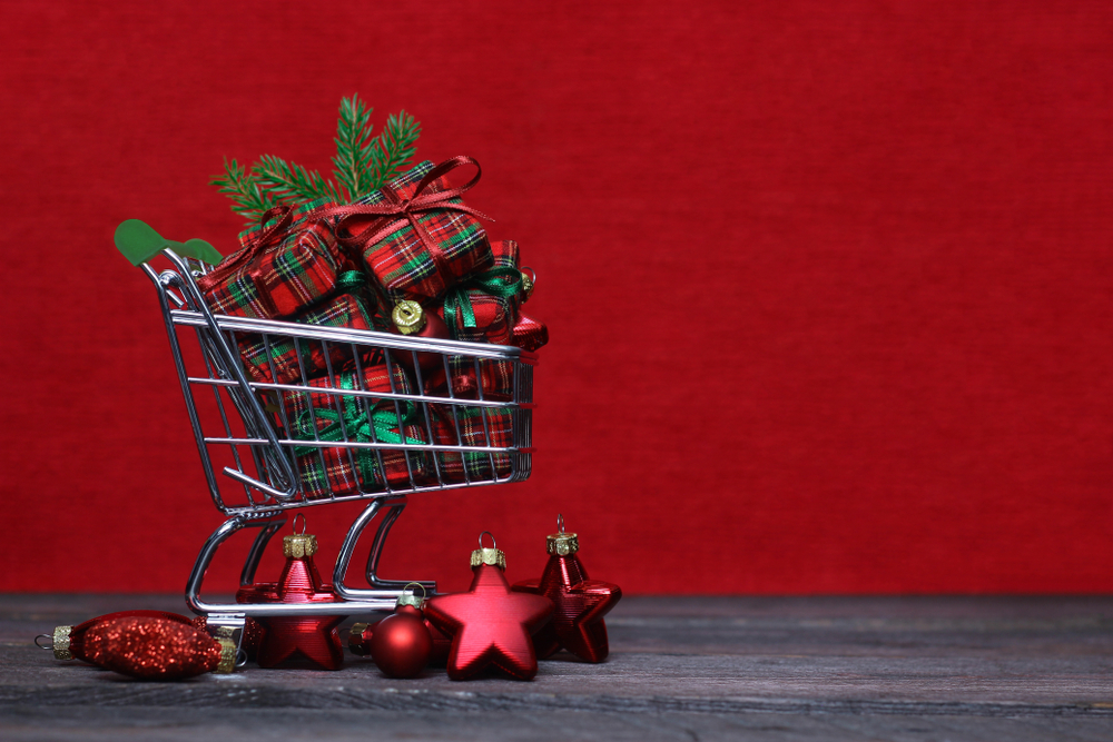 ChristmasShoppingCartWithPresentsAndOrnamentsOnRedBackground