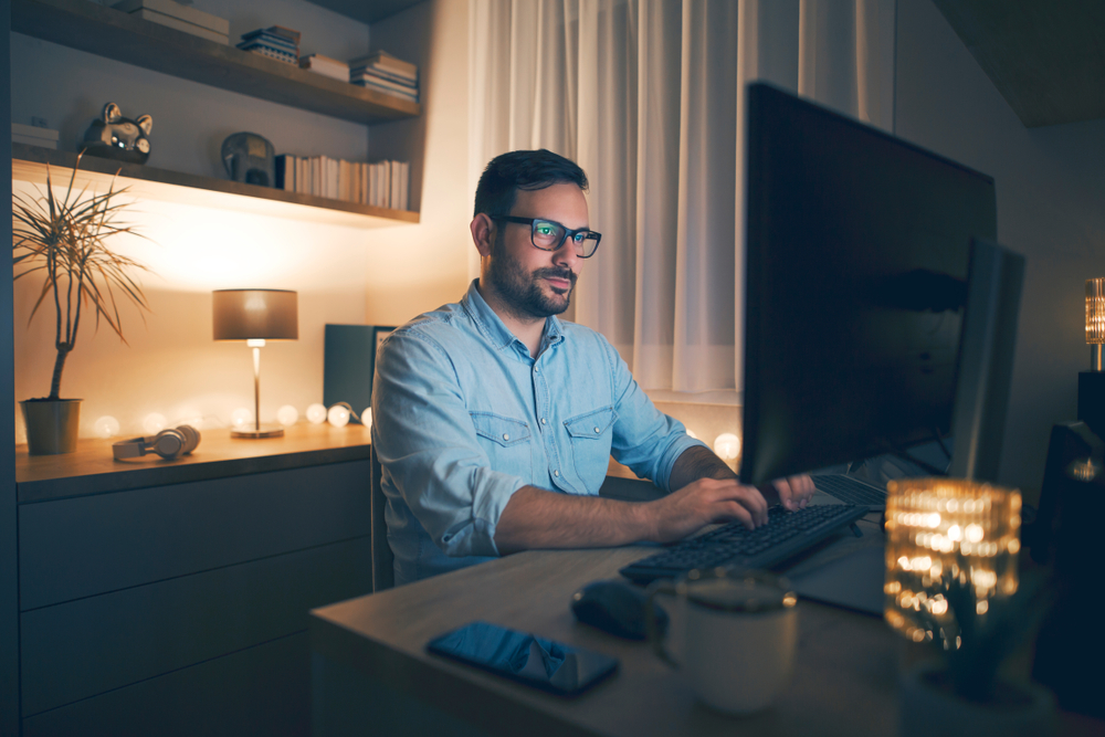 ModernYoungManWorkingRemotelyFromHomeAtNight