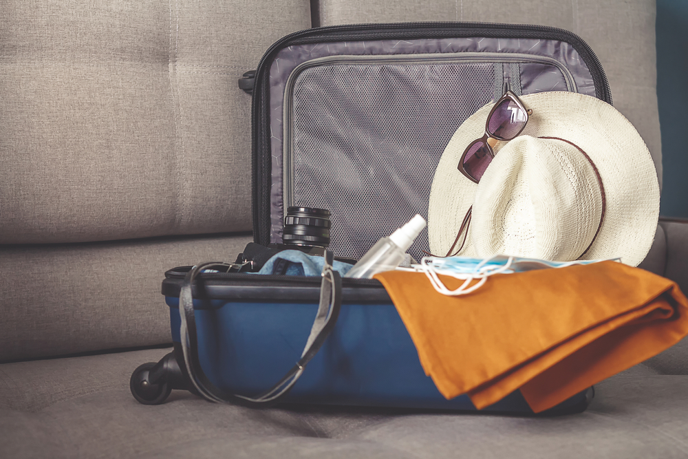TravelMaskedGirlPutsHerThingsInASuitcaseAnd