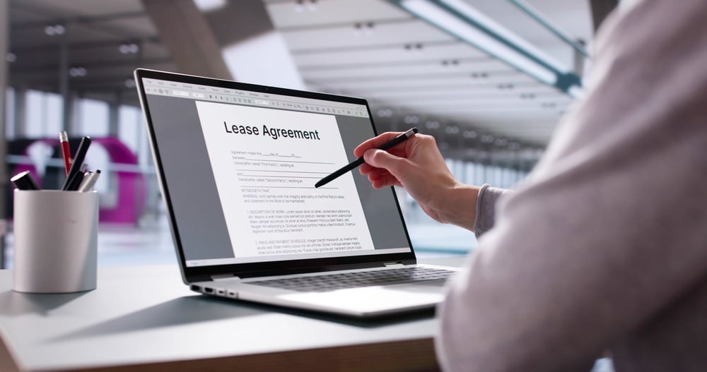 Copier Lease Agreement Definition & How It Works Woman reviews lease agreement contract on laptop computer for new car. Potential professions: real estate agent, financial advisor, insurance broker, business owner.