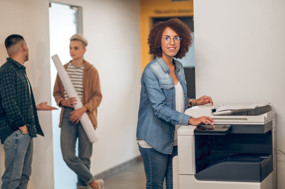 Managed Print Services Houston Guide for Optimized Printing Experienced secretary making document copies on the photocopier.