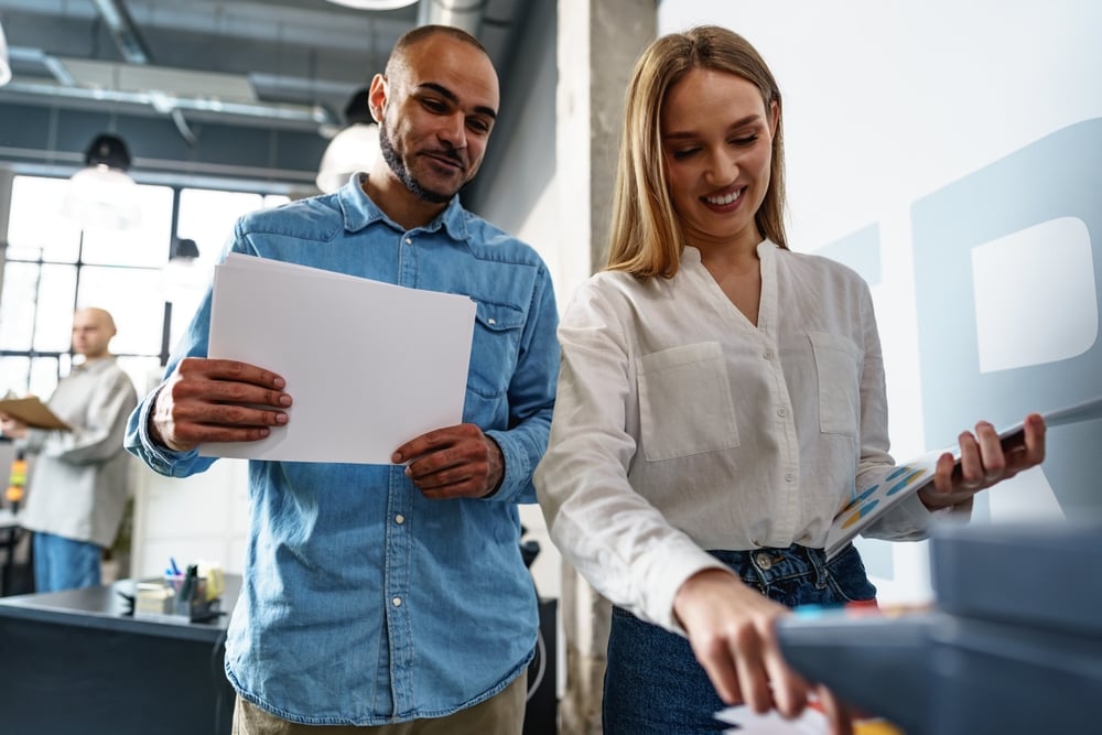 Print Environment Assessment: Benefits & Best Practices Two employees using new modern printer in office
