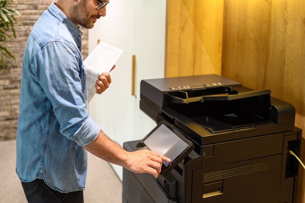 What to Expect During the Managed Print Service Process Midsection of male accountant making photocopies of reports through computer printer in modern workplace