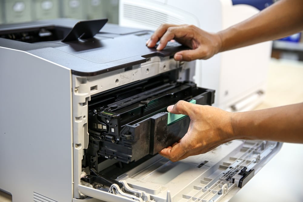 Technician hand open cover printer photocopier or photocopy to replace ink cartridges or fix paper jam for scanning fax or copy document in office workplace.