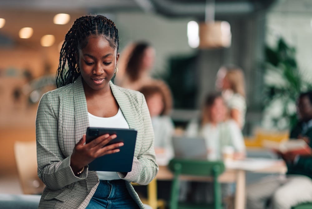 Connected Office Technology: A Guide for Businesses Black businesswoman working with digital tablet enjoying modern technology and diverse professional environment