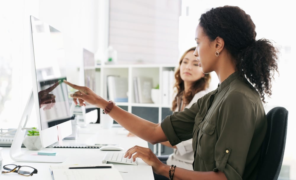 What Is a Searchable PDF and Why Does It Matter? People, research and discussion in office with computer, journalist collaboration and news for agency. Creative, women and pointing in workplace with desktop, conversation or advice for blog article.
